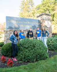 Students standing in front of entrance sign