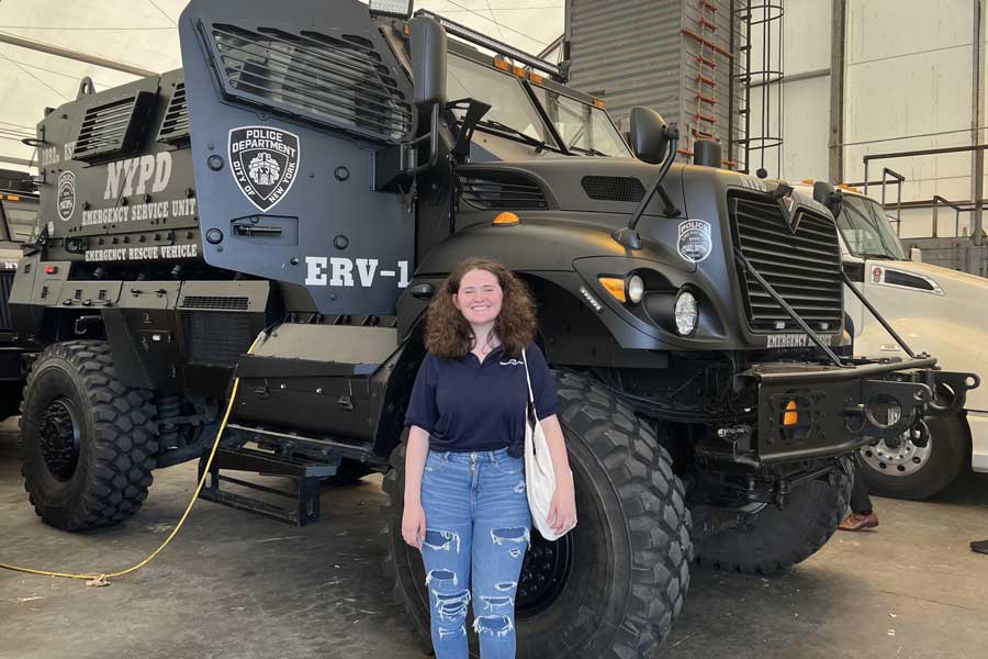 Emma Weir in front of NYPD vehicle