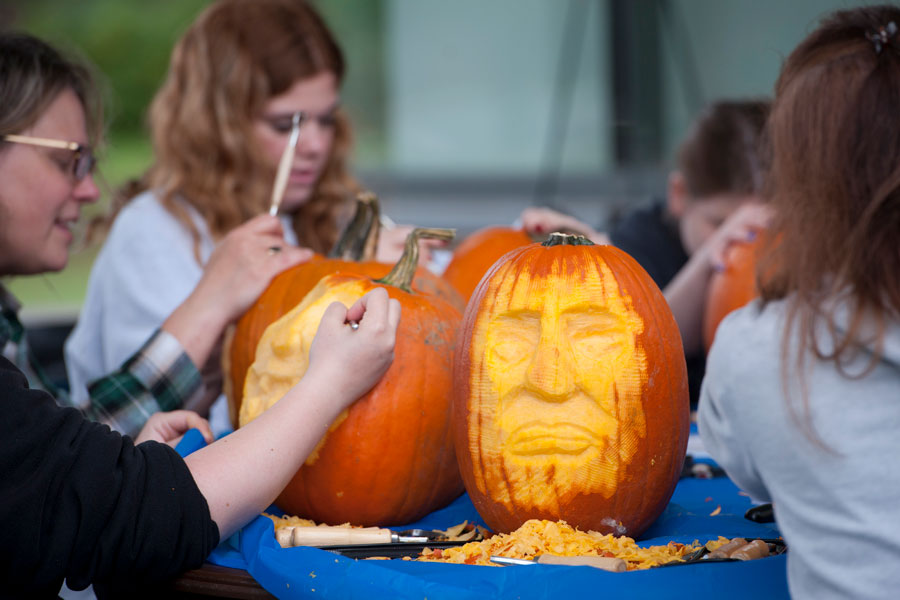 People carving faces into pumpkins