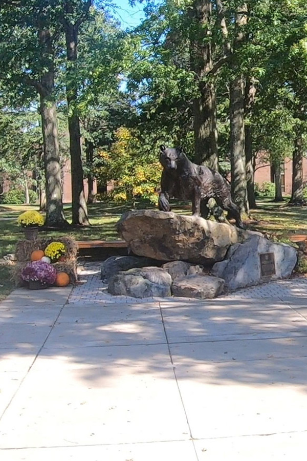 Students walking by panther statue