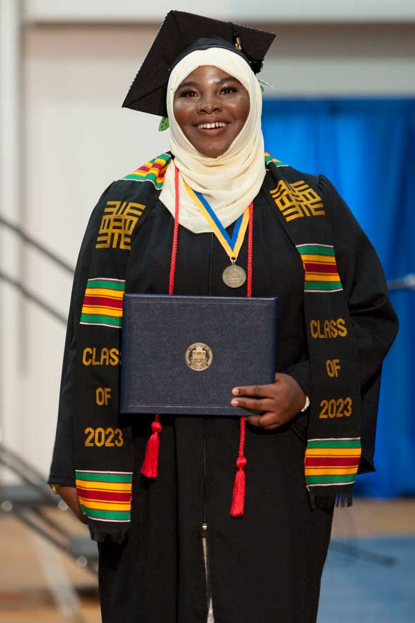 Two graduates holding diploma