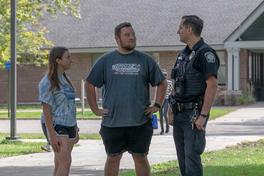 Students talking with campus police officer