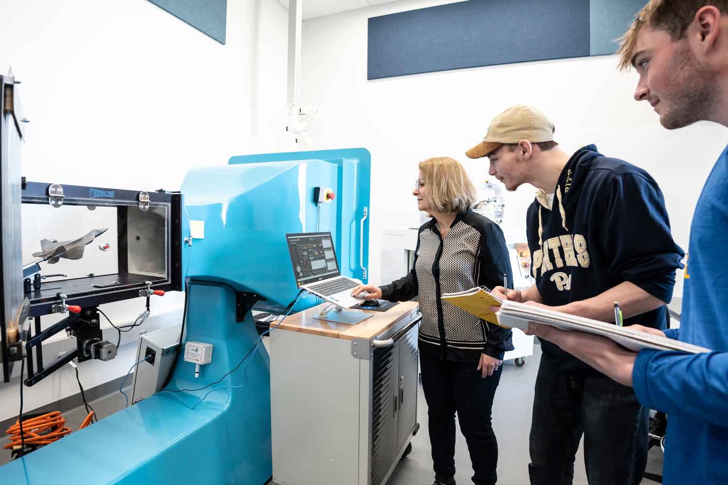 students working with a professor at the wind tunnel