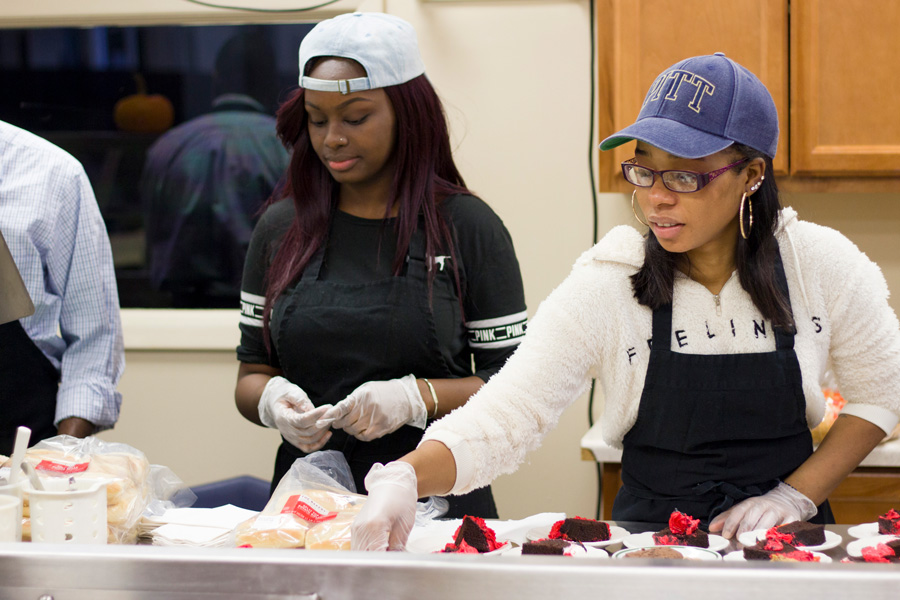 Students serving food at a food kitchen.