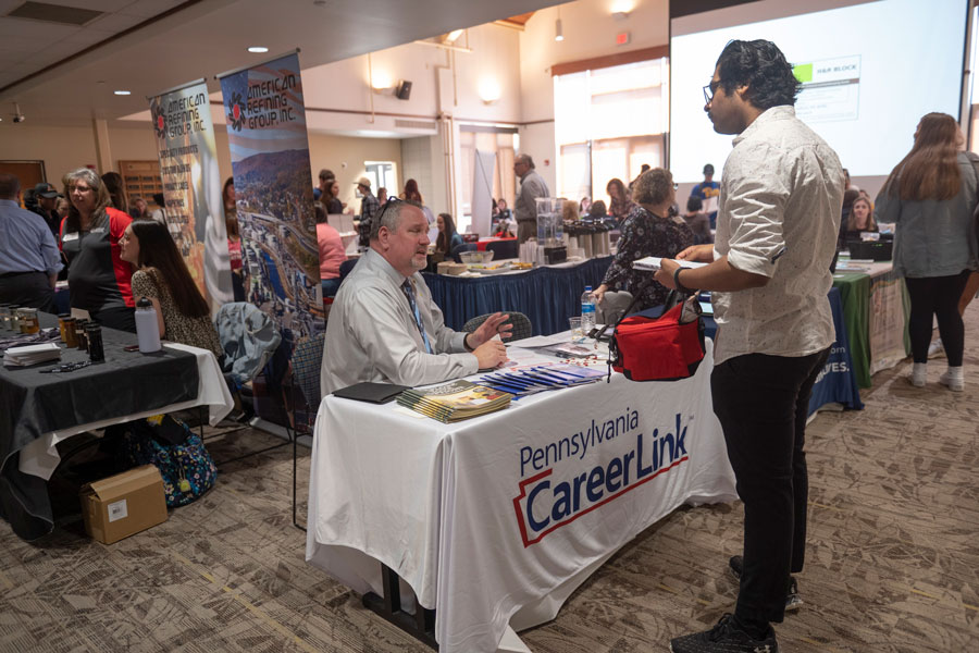 A student at the career fair in front of the CareerLink table