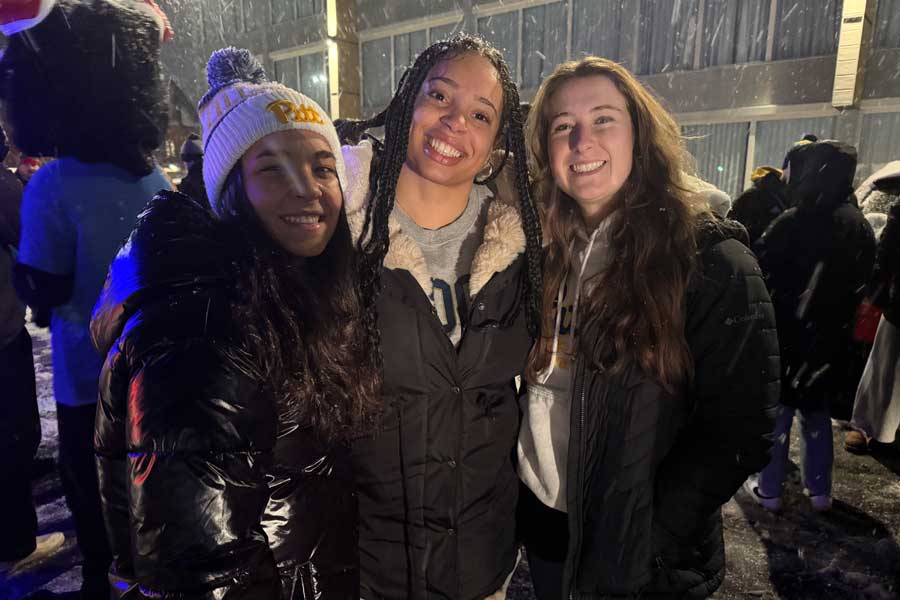 Three students standing together in the snow