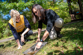 Student and teacher inspecting dirt