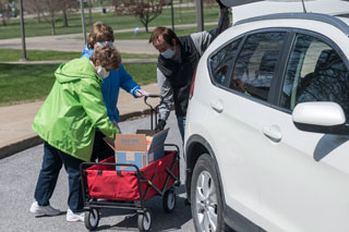 People Loading Food into Minivan