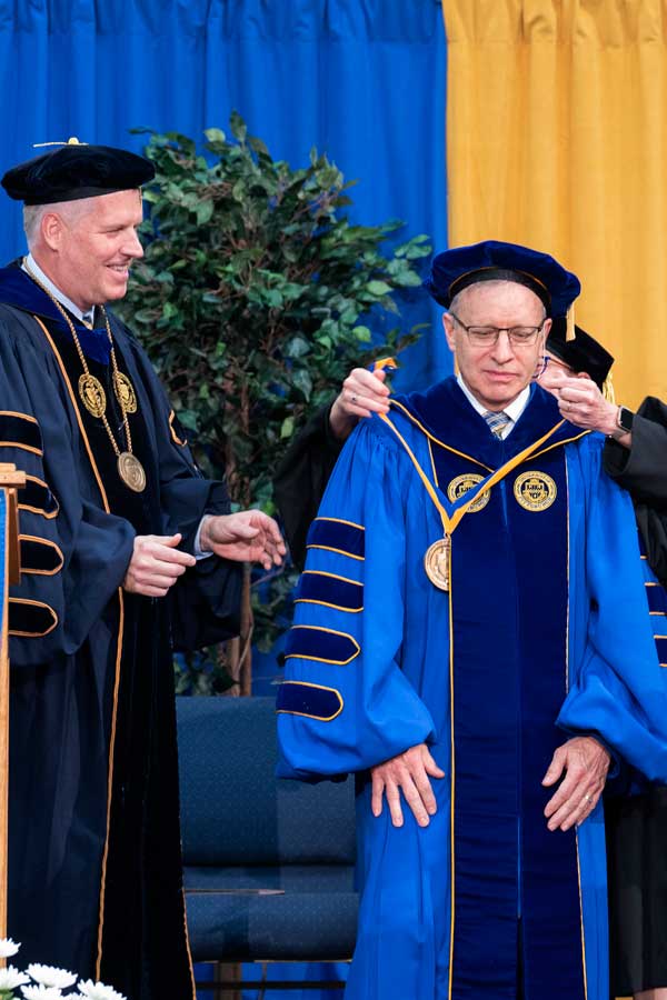 Richard T. Esch, president of the University of Pittsburgh’s Bradford and Titusville campuses, receives the presidential medal from Ann Cudd, University of Pittsburgh provost and senior vice chancellor, as Chancellor Patrick Gallagher looks on during the inauguration