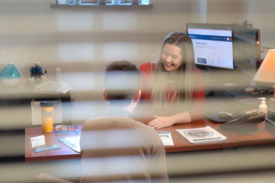 A student with a financial aid counselor in the financial aid office