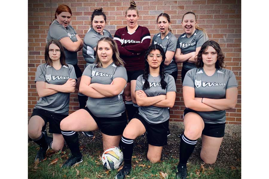 9 female actors in grey soccer uniforms for their production "The Wolves"