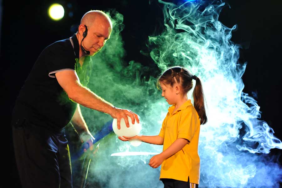 A man holding a bubble with a little girl