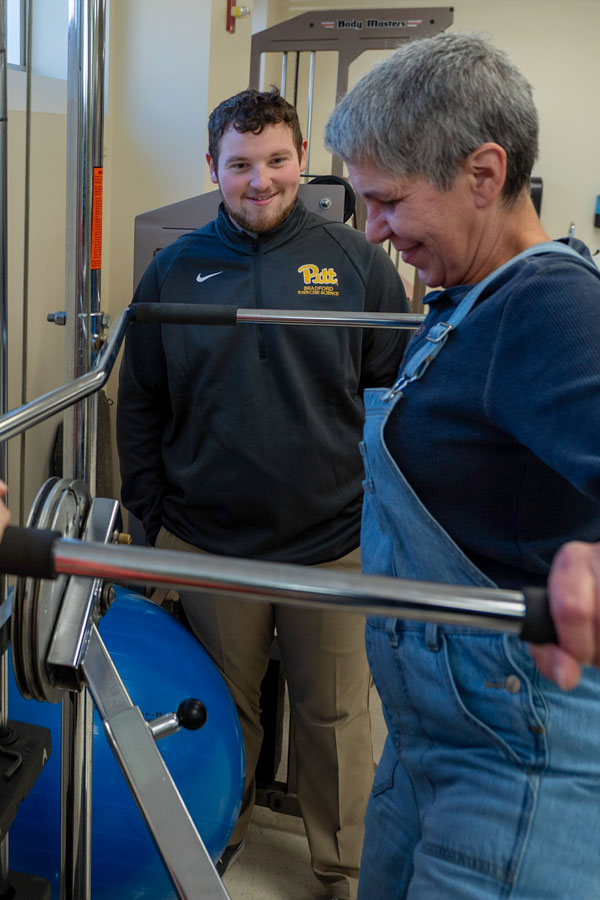 Nathan standing in the background observing a patient