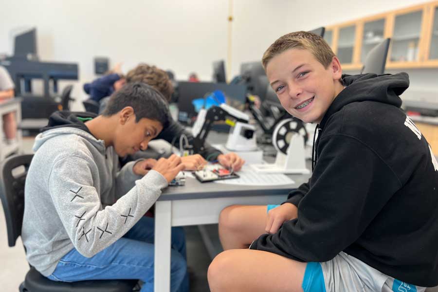 Two boys working on soldering wires