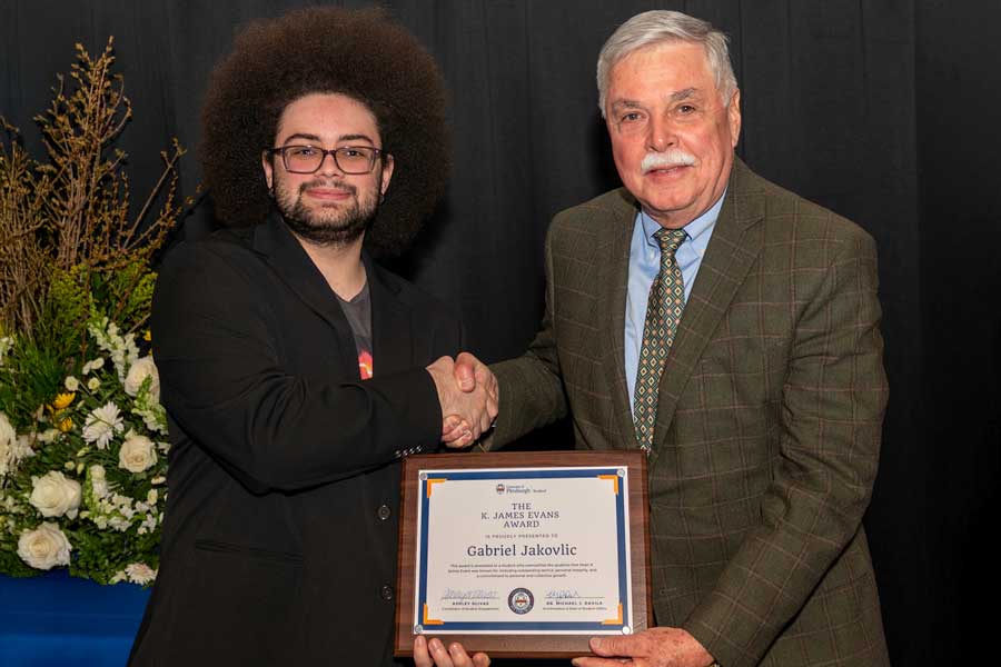 Gabirel Jakovlic standing with James K. Evans with his award