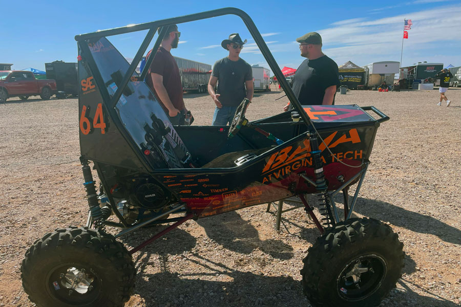 Members of Baja club behind a dune buggy