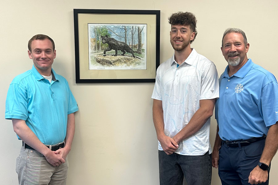 Chris and Gus Napoleon standing with Mychal Berlinski in front of a portrait of the panther statue