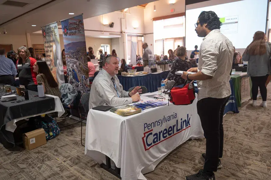 A student at the career fair in front of the CareerLink table
