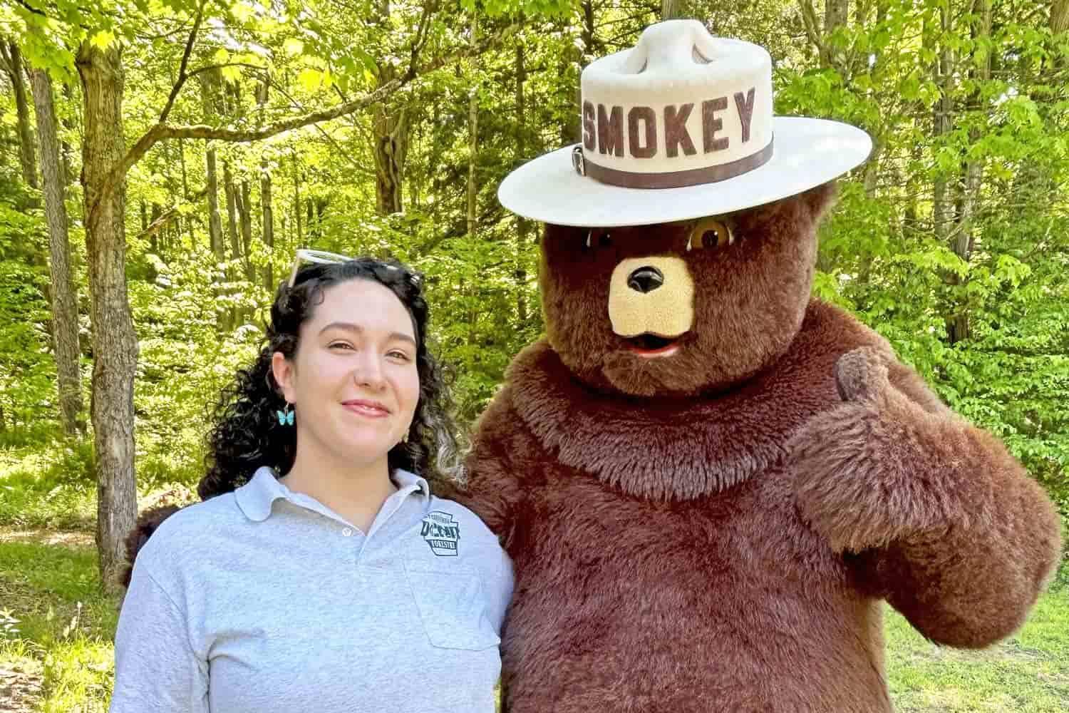 Sam Caulkins standing with Smokey the Bear