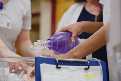 Students using a manual resuscitator on an infant manikin