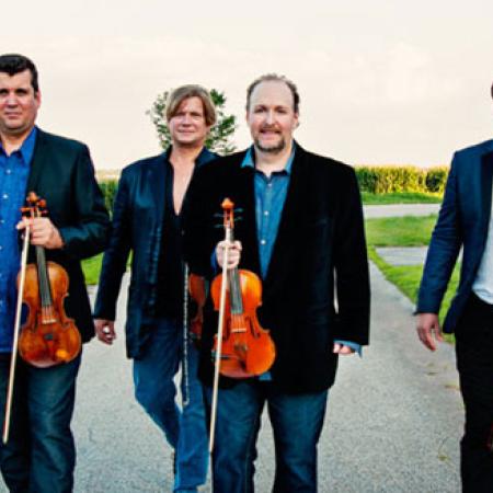 Members of the DePue Brothers band walking on a road with fiddles
