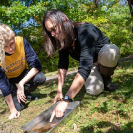 Student and teacher inspecting dirt