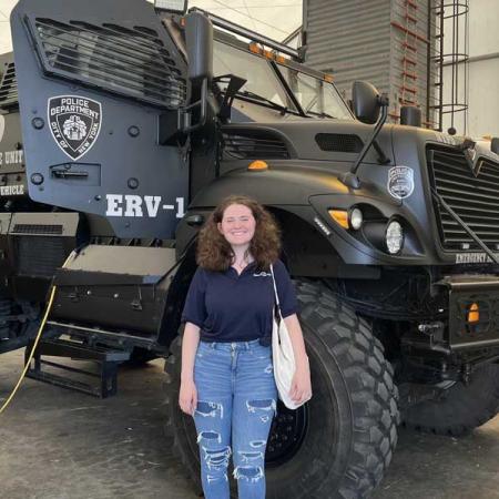 Emma Weir in front of NYPD vehicle