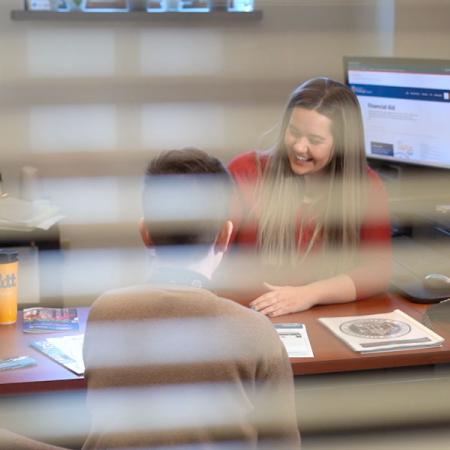A student with a financial aid counselor in the financial aid office