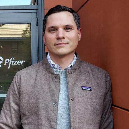  Dr. John Androsavich standing in front of a door with "Pfizer" written on the door pane