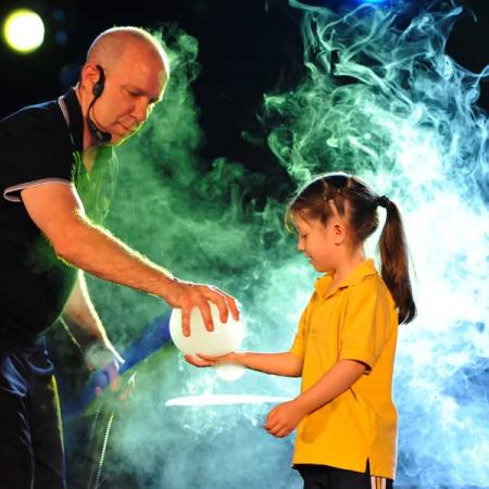 A man holding a bubble with a little girl