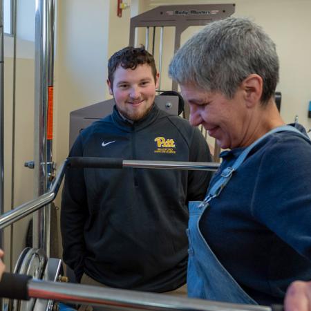 Nathan standing in the background observing a patient