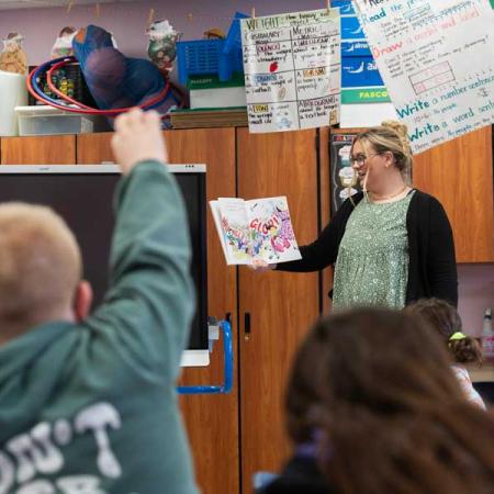 A student teacher reading to children in class