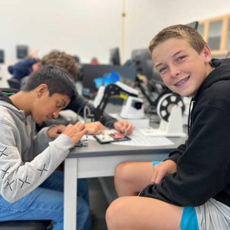 Two boys working on soldering wires
