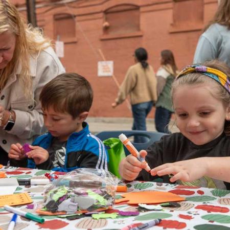 Children crafting and coloring at a table during pumpkinfest
