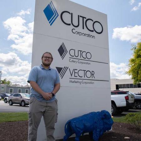 Billy standing in front of the Cutco sign