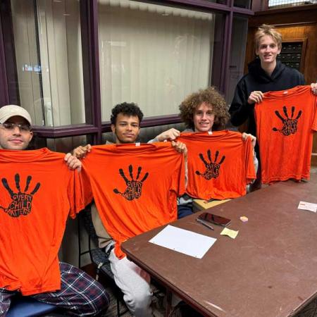 Lacrosse players holding orange t-shirts