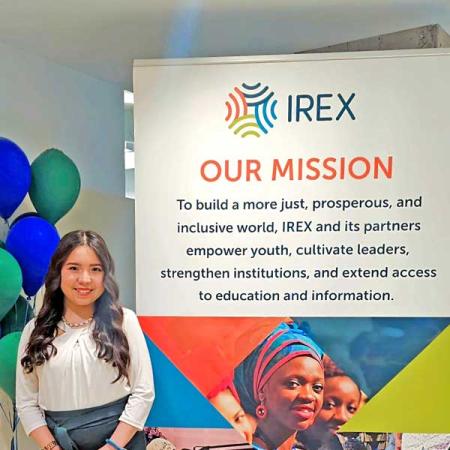 Ezoza standing next to an IREX sign