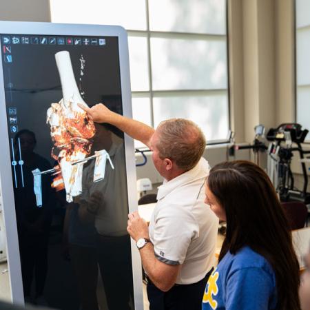 professor showing joint on anatomage table