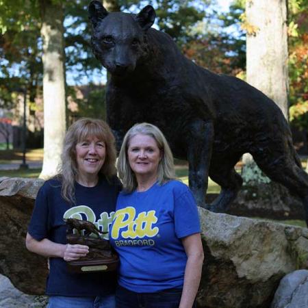 Kathy Moonan and Tammy Luciano in front of the panther statue