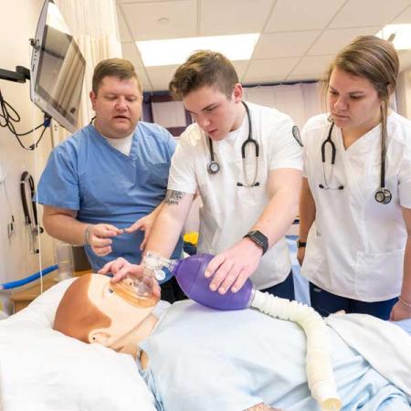 nursing students practicing on a dummy