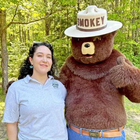 Sam standing with Smokey Bear