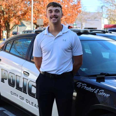 Joe standing in front of a police car