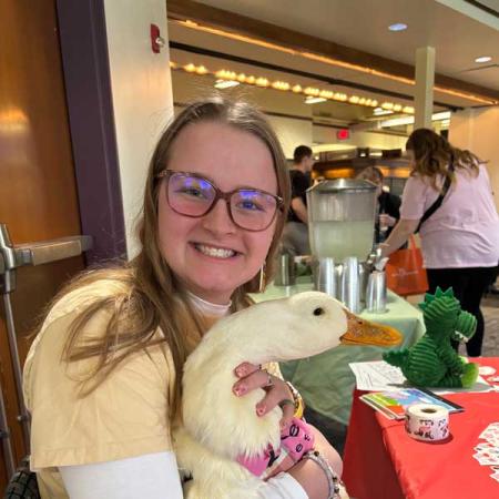 A person holding a therapy duck for family literacy day activities
