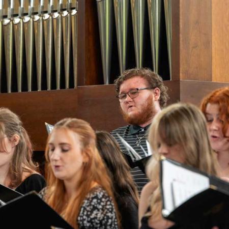 Students singing in the choir at the vocal ensemble performance