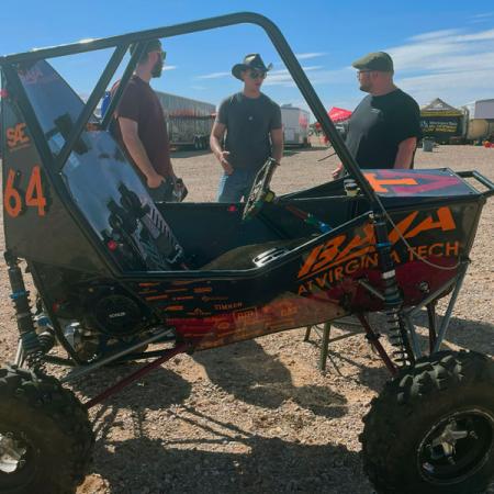 Members of Baja club behind a dune buggy