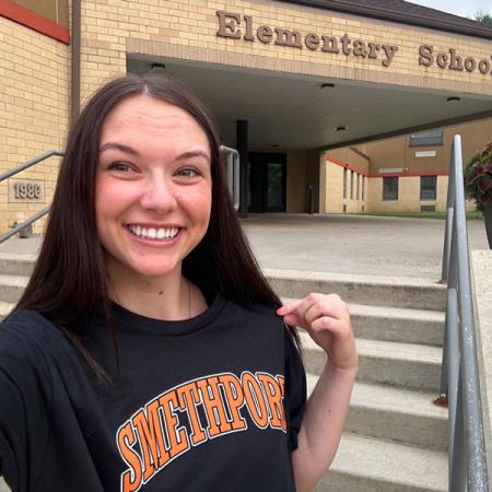 Gretchen standing in front of a school